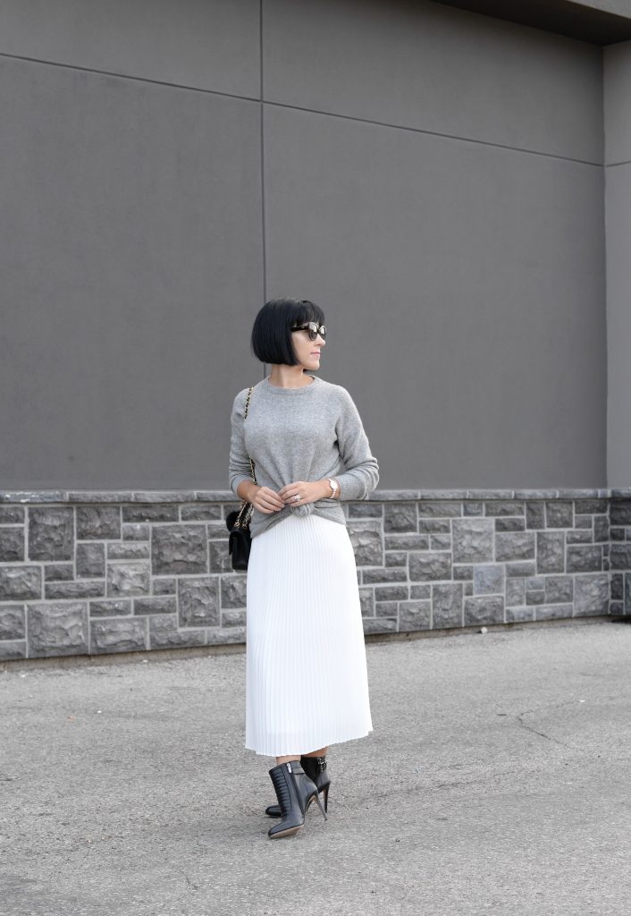 Pleats Are Back, spring skirt, what to wear this spring, grey Cashmere Sweater, Aritzia sweater, Chanel Double Flap, Bulova watch, toms Sunglasses, white Pleated Skirt, Aritzia skirt, Vince Camuto booties, black booties