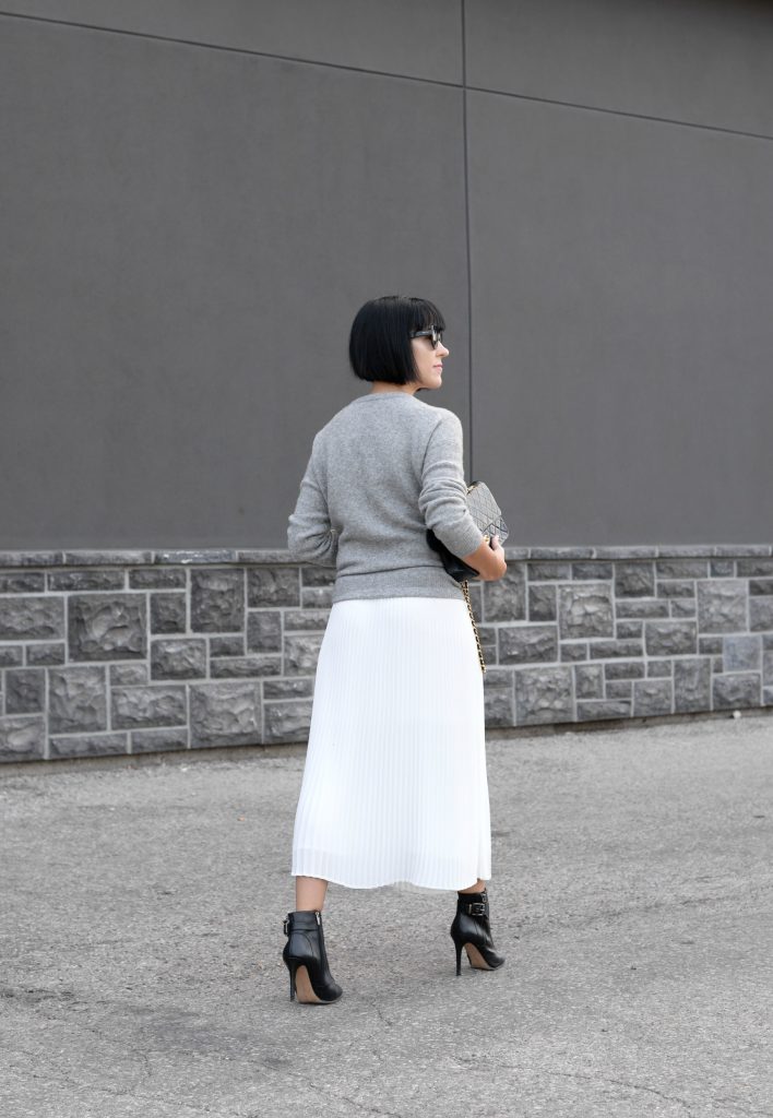 Pleats Are Back, spring skirt, what to wear this spring, grey Cashmere Sweater, Aritzia sweater, Chanel Double Flap, Bulova watch, toms Sunglasses, white Pleated Skirt, Aritzia skirt, Vince Camuto booties, black booties