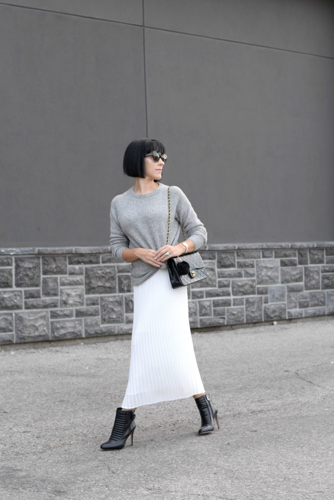 Pleats Are Back, spring skirt, what to wear this spring, grey Cashmere Sweater, Aritzia sweater, Chanel Double Flap, Bulova watch, toms Sunglasses, white Pleated Skirt, Aritzia skirt, Vince Camuto booties, black booties
