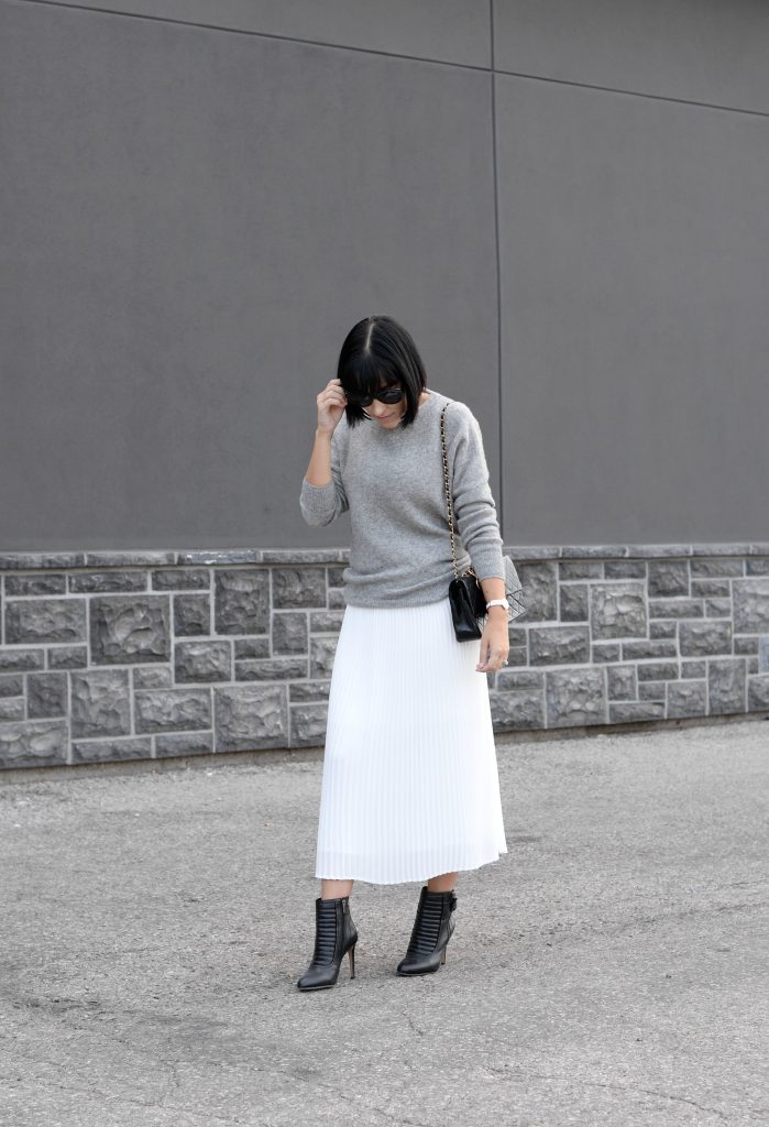 Pleats Are Back, spring skirt, what to wear this spring, grey Cashmere Sweater, Aritzia sweater, Chanel Double Flap, Bulova watch, toms Sunglasses, white Pleated Skirt, Aritzia skirt, Vince Camuto booties, black booties