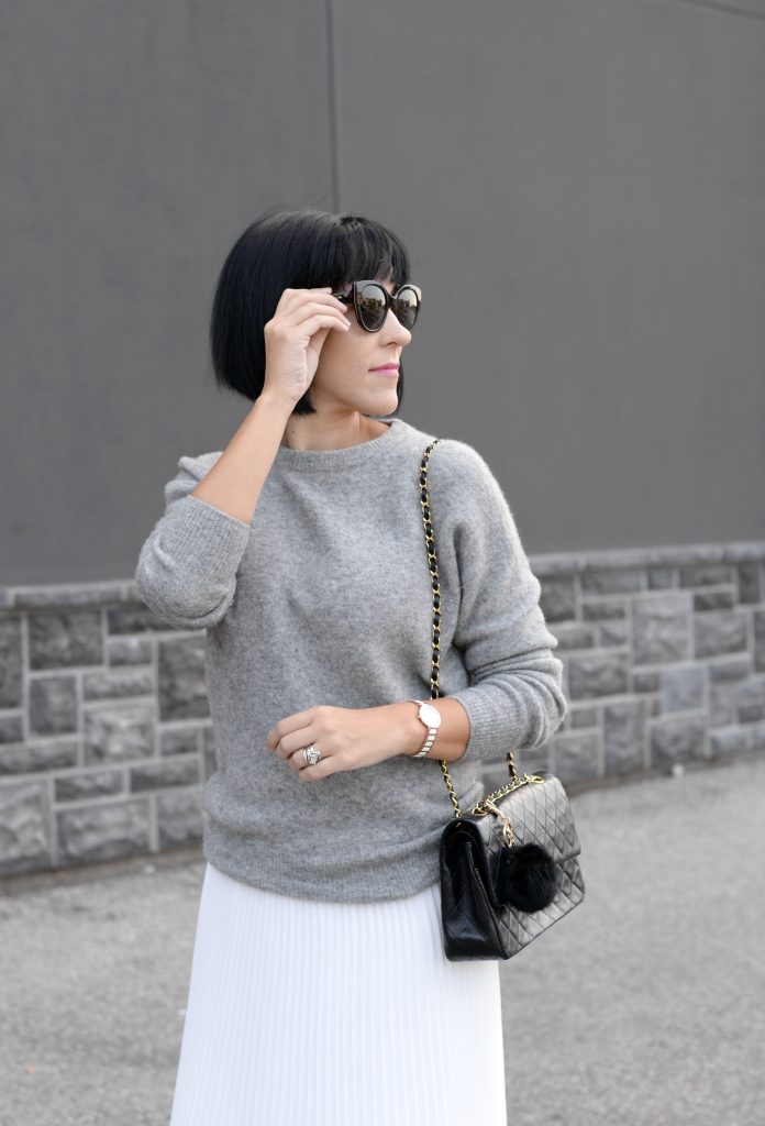 Pleats Are Back, spring skirt, what to wear this spring, grey Cashmere Sweater, Aritzia sweater, Chanel Double Flap, Bulova watch, toms Sunglasses, white Pleated Skirt, Aritzia skirt, Vince Camuto booties, black booties