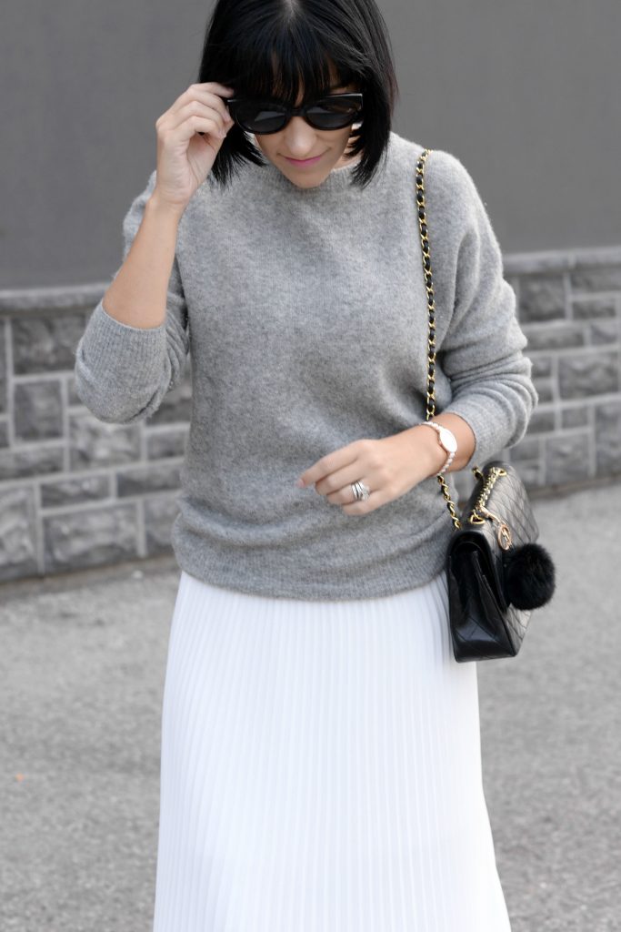 Pleats Are Back, spring skirt, what to wear this spring, grey Cashmere Sweater, Aritzia sweater, Chanel Double Flap, Bulova watch, toms Sunglasses, white Pleated Skirt, Aritzia skirt, Vince Camuto booties, black booties